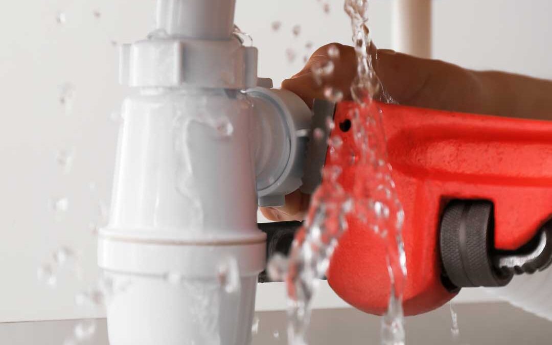 A person operates a water pump to clean a sink, directing water flow for effective cleaning